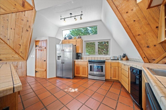 19028 Rocky Trl, Lakehead, CA 96051 - kitchen featuring stainless steel appliances, tile counters, lofted ceiling, light tile patterned floors, and light brown cabinetry