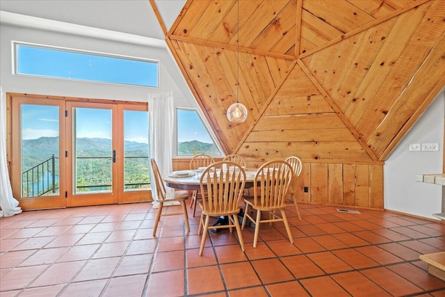 19028 Rocky Trl, Lakehead, CA 96051 - dining room with light tile patterned floors, a mountain view, lofted ceiling, wooden walls, and french doors