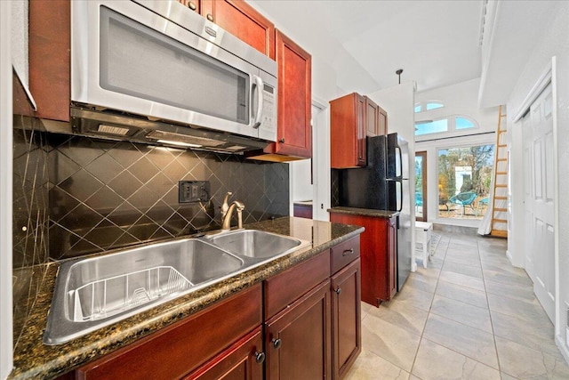 19028 Rocky Trl, Lakehead, CA 96051 - kitchen with stainless steel microwave, reddish brown cabinets, decorative backsplash, and freestanding refrigerator