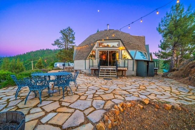 19028 Rocky Trl, Lakehead, CA 96051 - back of property at dusk with a patio area and outdoor dining area