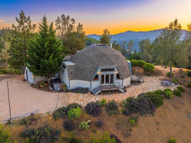 19028 Rocky Trl, Lakehead, CA 96051 - back of property at dusk with a mountain view and roof with shingles