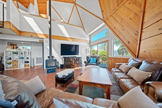 19028 Rocky Trl, Lakehead, CA 96051 - living room with high vaulted ceiling, a wood stove, tile patterned flooring, and wooden walls