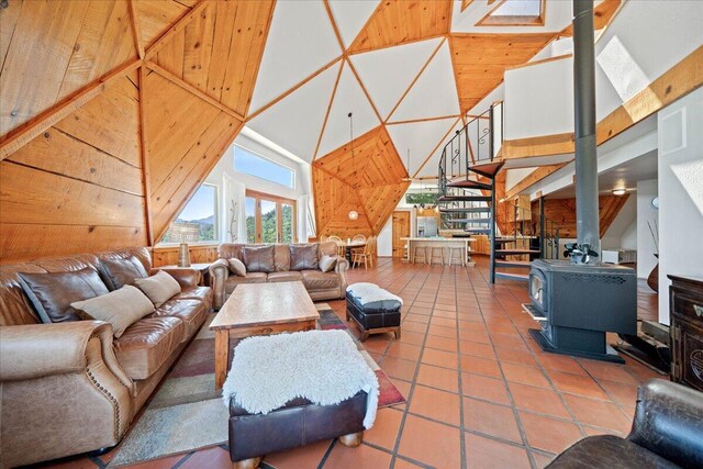 19028 Rocky Trl, Lakehead, CA 96051 - tiled living area with high vaulted ceiling, a wood stove, and wood walls