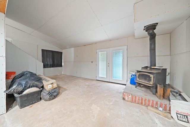 13599 Oak Run Rd, Oak Run, CA 96069 - unfurnished living room with a wood stove, concrete flooring, french doors, and vaulted ceiling