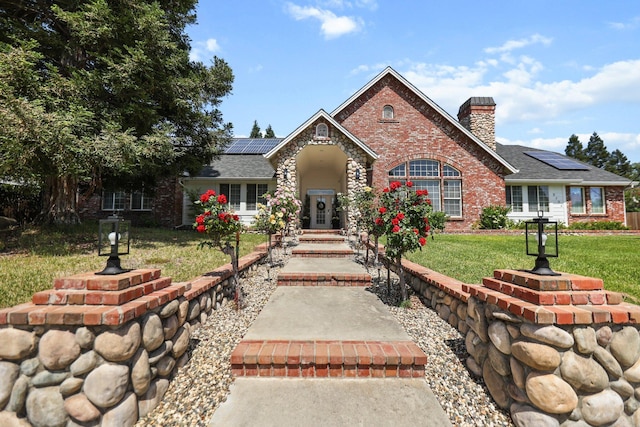 2154 Harvard Way, Redding, CA 96003 - traditional-style home featuring a chimney, solar panels, brick siding, and a front lawn