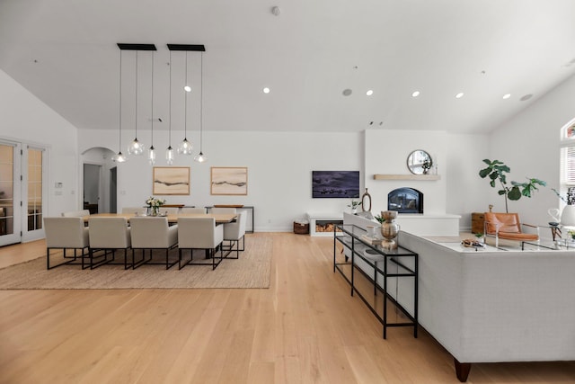 2154 Harvard Way, Redding, CA 96003 - living area with light wood-style floors, vaulted ceiling, arched walkways, recessed lighting, and a glass covered fireplace