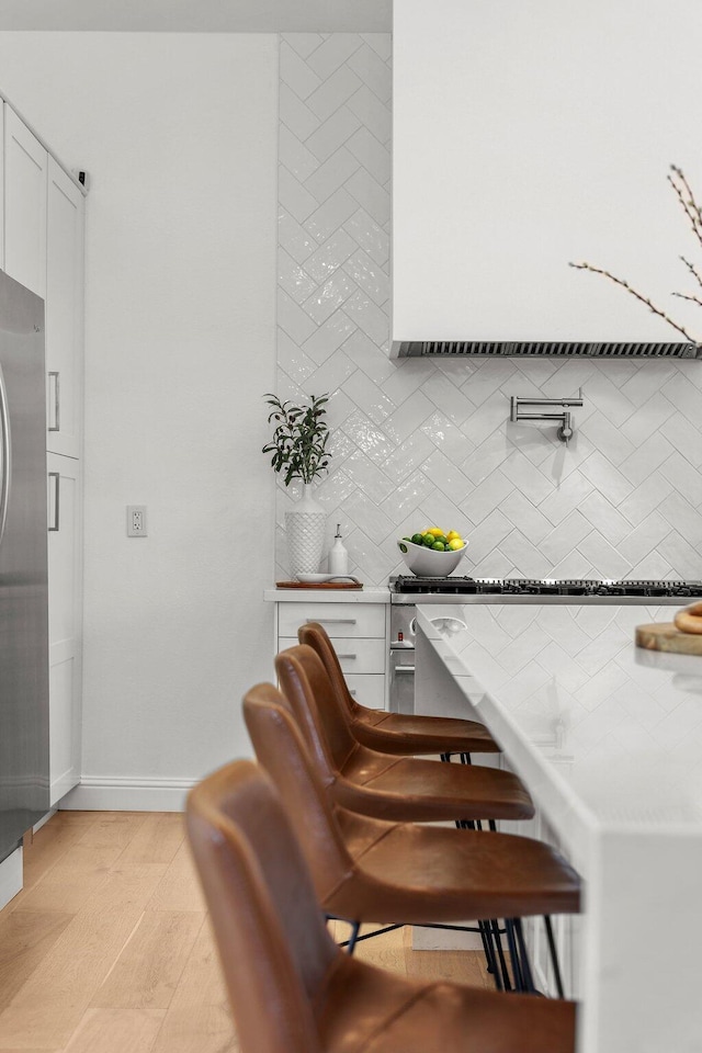 2154 Harvard Way, Redding, CA 96003 - bar with decorative backsplash, light wood-style floors, and baseboards
