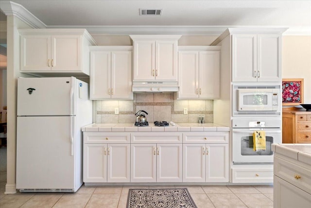 110 Agua Verdi Dr, Red Bluff, CA 96080 - kitchen featuring white appliances, under cabinet range hood, tile counters, white cabinets, and ornamental molding