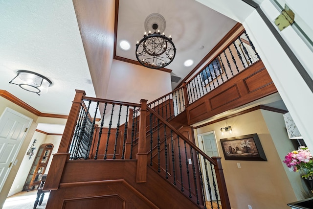 2990 Forest Hills Dr, Redding, CA 96002 - stairway featuring a chandelier, crown molding, a towering ceiling, and baseboards