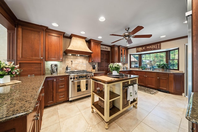 2990 Forest Hills Dr, Redding, CA 96002 - kitchen with high end stove, custom range hood, ceiling fan, backsplash, and ornamental molding