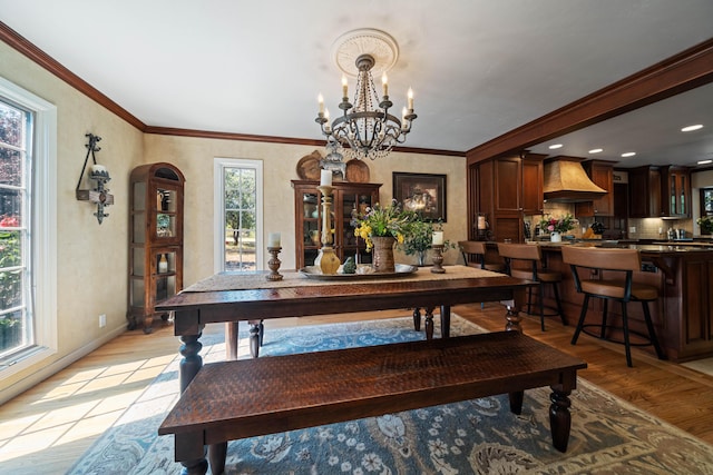 2990 Forest Hills Dr, Redding, CA 96002 - dining room featuring light wood-style flooring, a chandelier, baseboards, arched walkways, and crown molding