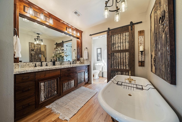 2990 Forest Hills Dr, Redding, CA 96002 - bathroom featuring wood finished floors, a soaking tub, double vanity, and toilet