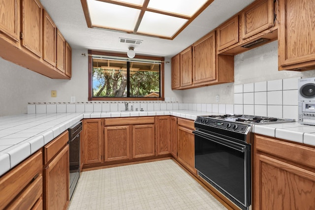 1152 Edgewood Dr, Redding, CA 96003 - kitchen with black appliances, tile countertops, brown cabinets, a sink, and decorative backsplash