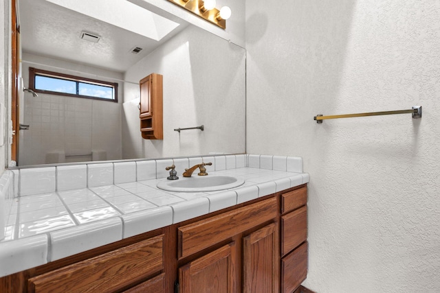 1152 Edgewood Dr, Redding, CA 96003 - full bathroom featuring a textured wall, vanity, and a shower