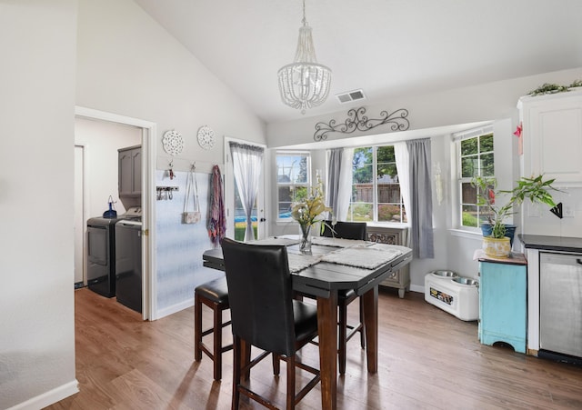 2773 Crystal Tree Dr, Redding, CA 96001 - dining space with washing machine and dryer, a chandelier, wood finished floors, baseboards, and high vaulted ceiling