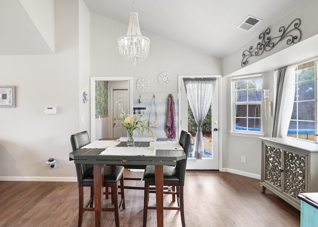 2773 Crystal Tree Dr, Redding, CA 96001 - dining area with a chandelier, wood finished floors, baseboards, and high vaulted ceiling