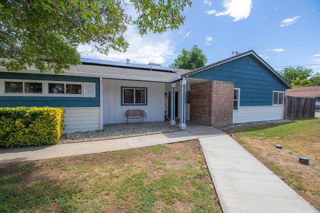 75 Sherman Dr, Red Bluff, CA 96080 - single story home with roof mounted solar panels, covered porch, board and batten siding, and a front yard