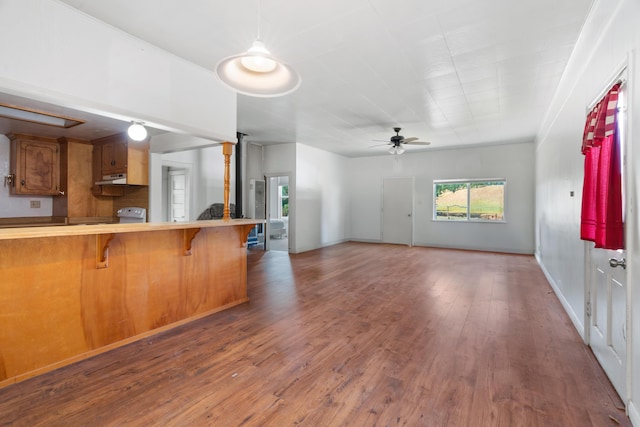 18555 Live Oak Rd, Red Bluff, CA 96080 - kitchen featuring ceiling fan, brown cabinetry, wood finished floors, a breakfast bar, and under cabinet range hood