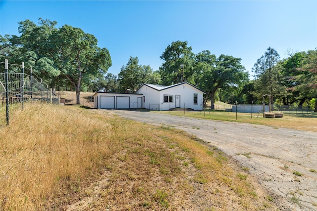 18555 Live Oak Rd, Red Bluff, CA 96080 - view of front of home featuring fence, a garage, driveway, and view of wooded area