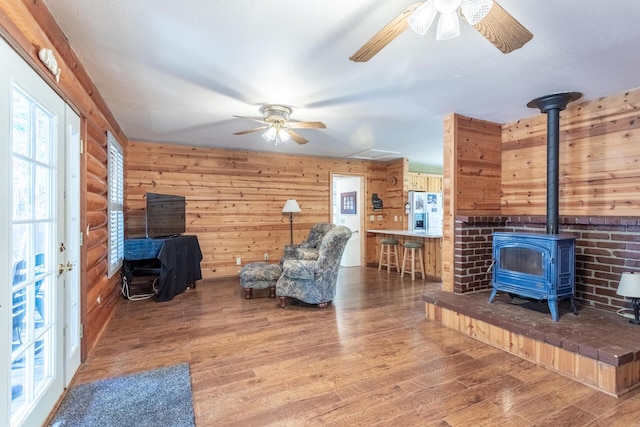35267 Nehemiah Dr, Shingletown, CA 96088 - living area with ceiling fan, a wood stove, wood finished floors, and wooden walls