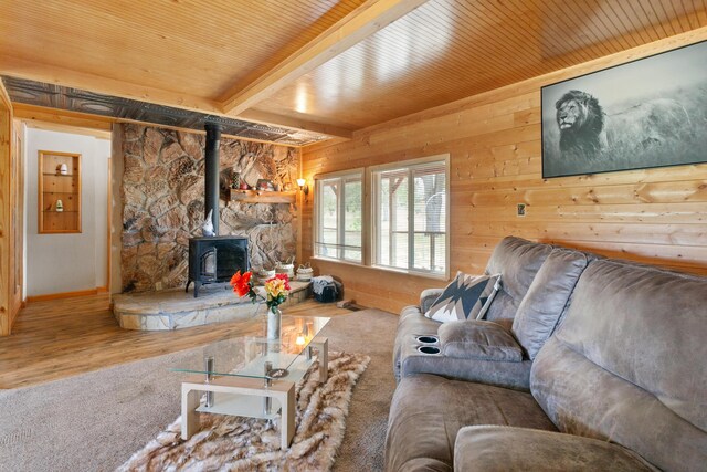 27339 Hobart Rd, Shingletown, CA 96088 - carpeted living room featuring a wood stove, wood walls, beam ceiling, wood finished floors, and wood ceiling