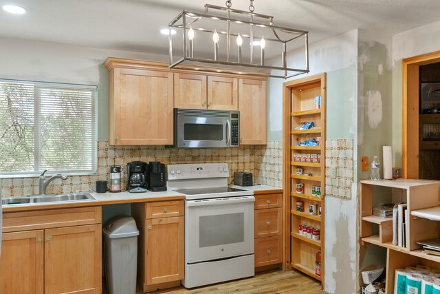 27339 Hobart Rd, Shingletown, CA 96088 - kitchen with stainless steel microwave, white range with electric stovetop, a sink, and decorative backsplash