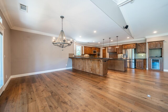 kitchen with stainless steel appliances, dark countertops, hardwood / wood-style floors, a chandelier, and baseboards