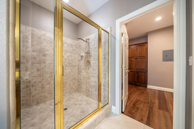 bathroom featuring a shower stall, electric panel, wood finished floors, recessed lighting, and baseboards