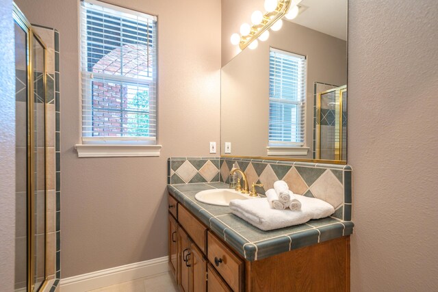 full bathroom with backsplash, a shower stall, vanity, and tile patterned floors