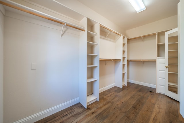 walk in closet featuring dark wood finished floors