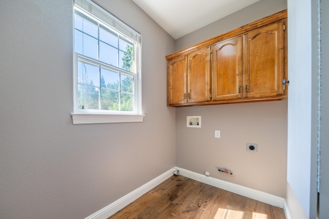 clothes washing area featuring electric dryer hookup, baseboards, hookup for a gas dryer, washer hookup, and cabinet space