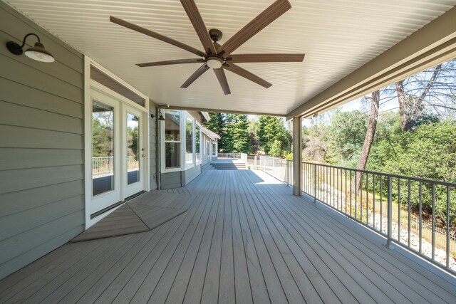 deck with ceiling fan and view of wooded area