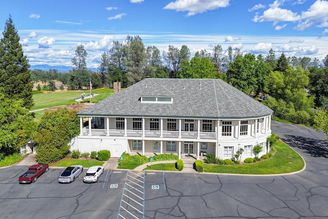 view of building exterior featuring uncovered parking and view of scattered trees