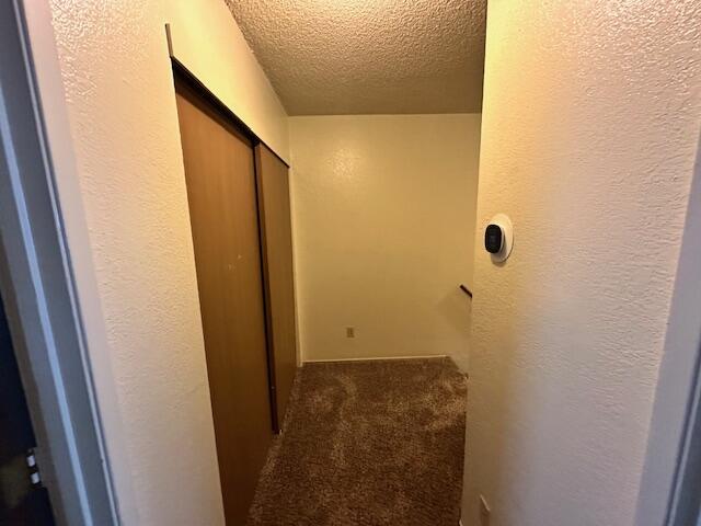 3580 Ricardo Ave, Redding, CA 96002 - corridor featuring a textured ceiling, carpet, and a textured wall