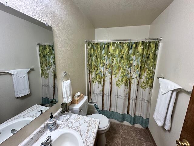 3580 Ricardo Ave, Redding, CA 96002 - bathroom with toilet, shower / bath combo, vanity, a textured wall, and tile patterned floors