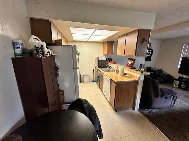 3580 Ricardo Ave, Redding, CA 96002 - kitchen with light floors, a sink, white appliances, and light countertops