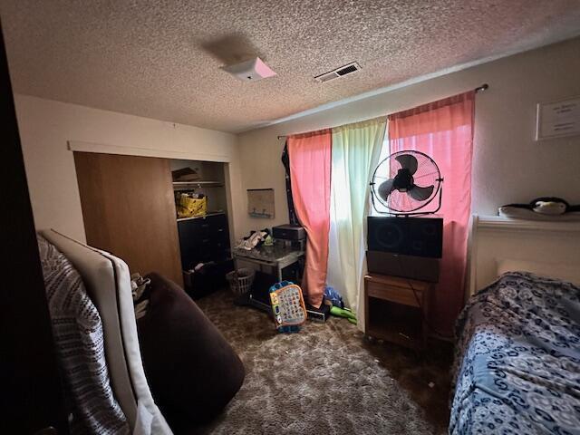 3580 Ricardo Ave, Redding, CA 96002 - carpeted bedroom with a textured ceiling and a closet