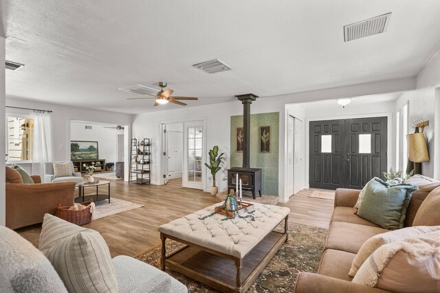 19186 Knighton Rd, Redding, CA 96001 - living area with a wood stove, ceiling fan, light wood finished floors, and baseboards