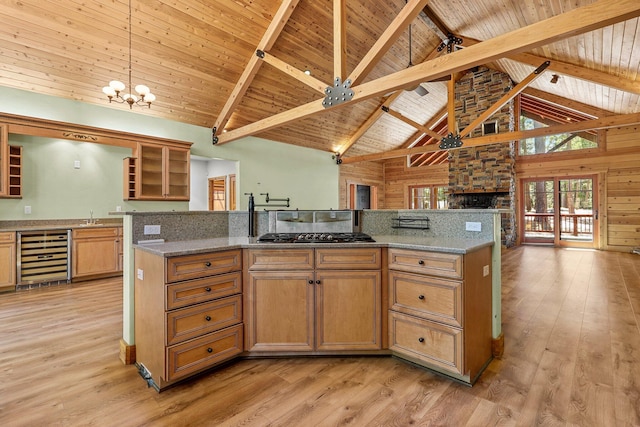 7185 Whispering Winds Ct, Shingletown, CA 96088 - kitchen with beverage cooler, gas cooktop, light wood-style flooring, open floor plan, and high vaulted ceiling