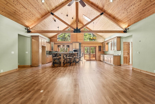 7185 Whispering Winds Ct, Shingletown, CA 96088 - living room with high vaulted ceiling, light wood-type flooring, a ceiling fan, wooden ceiling with exposed beams, and baseboards