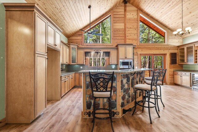 7185 Whispering Winds Ct, Shingletown, CA 96088 - kitchen featuring stainless steel microwave, wooden ceiling, healthy amount of natural light, high vaulted ceiling, and wood walls