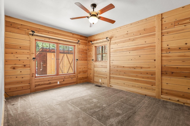 7185 Whispering Winds Ct, Shingletown, CA 96088 - empty room featuring carpet flooring, wood walls, and ceiling fan