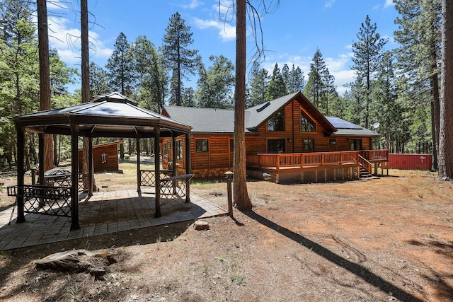 7185 Whispering Winds Ct, Shingletown, CA 96088 - rear view of property with a gazebo, a wooden deck, solar panels, a patio area, and log siding