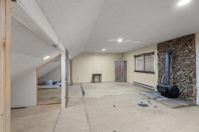 30681 Sleepy Hollow Dr, Shingletown, CA 96088 - unfurnished living room featuring a baseboard radiator, a wood stove, a textured ceiling, recessed lighting, and lofted ceiling