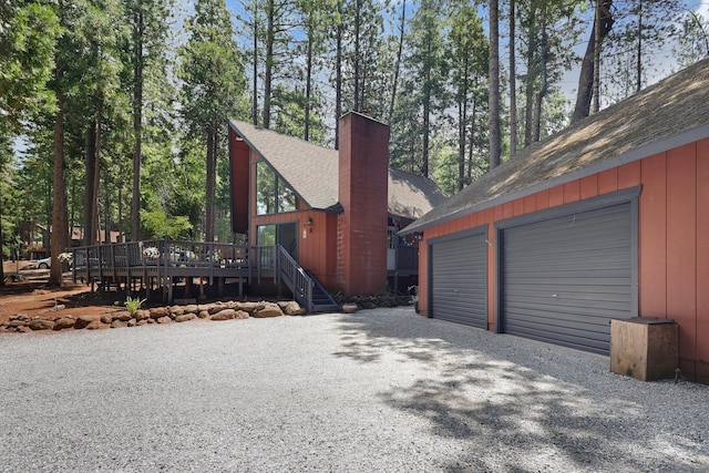 30681 Sleepy Hollow Dr, Shingletown, CA 96088 - view of side of home with a shingled roof, a chimney, a wooden deck, a garage, and an outdoor structure
