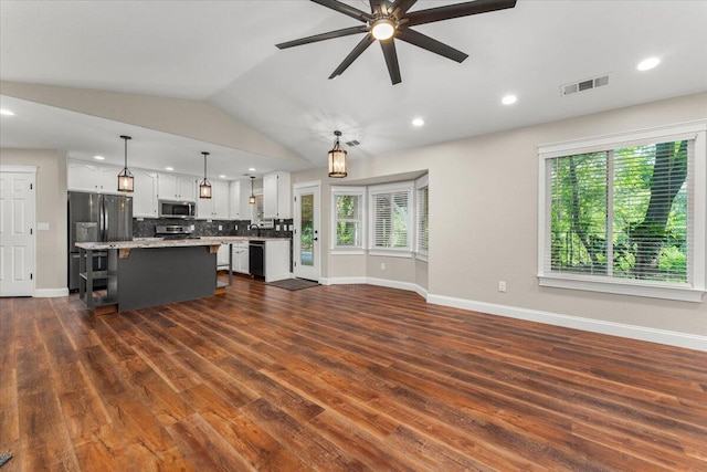507 Olympic St, Redding, CA 96003 - unfurnished living room featuring plenty of natural light, baseboards, vaulted ceiling, dark wood-style floors, and a ceiling fan