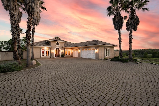 4684 Oak Glen Dr, Redding, CA 96001 - mediterranean / spanish house featuring a garage, decorative driveway, stucco siding, a tile roof, and french doors