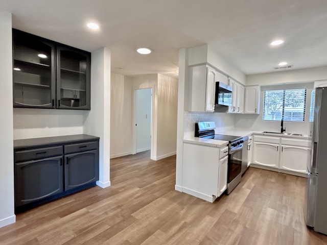 1808 Del Mar Ave, Redding, CA 96003 - kitchen featuring stainless steel appliances, light wood-style flooring, a sink, recessed lighting, and white cabinetry
