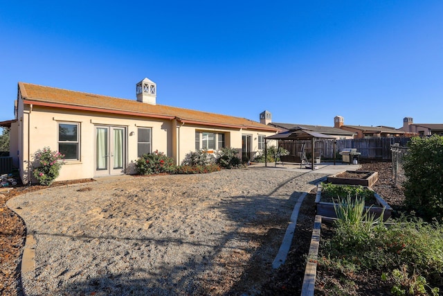 20284 Domaine Pl, Anderson, CA 96007 - rear view of house featuring a gazebo, french doors, a garden, fence, and stucco siding