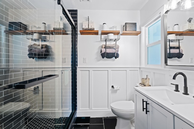 3689 Suzanne Way, Redding, CA 96002 - full bathroom featuring a shower stall, toilet, vanity, a decorative wall, and a wainscoted wall